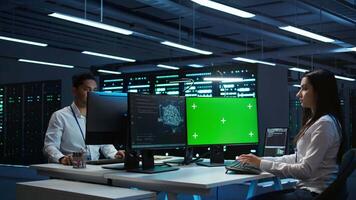 Technician doing checkup on green screen server hub PC to optimize it for data processing requirements of AI. Worker inspects data center used for machine learning using mockup computer, camera B video