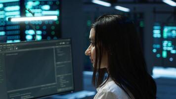 Portrait of cheerful engineer in data center installing software on computer, troubleshooting issues. Smiling IT specialist in server room establishing performance benchmarks video
