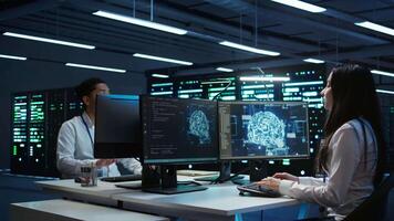 Team of engineers using AI tech on computer to do checkup in server room. Data center workers using artificial intelligence technology to process datasets for training, camera B video