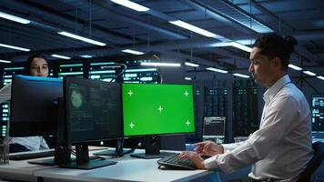 System administrator using AI tech on isolated screen PC to do maintenance in server room. Skilled expert in data center using artificial intelligence on chroma key to process datasets for training video