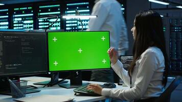 Admin in data center using mockup PC to design, implement and manage gear, ensuring optimal performance and reliability. Expert in server room coding on green screen computer, camera A video