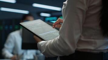 Engineer working in data center used for managing infrastructure rigs energy consumption. Employee using tablet in workplace used for automation and monitoring processes in server farm, camera A video