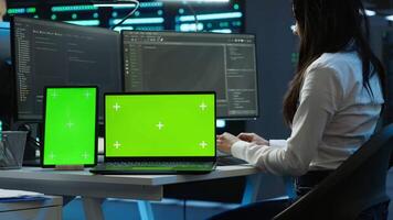 Engineers in data center monitoring security threats using chroma key devices. Experts using isolated screen tablet and laptop, ensuring compliance with regulations, camera A video