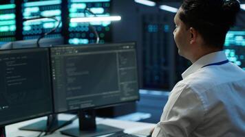Engineer overseeing data center, making routine improvements and updates to ensure system can handle all networking tasks. Server room employee tracking network traffic and activity, camera A video