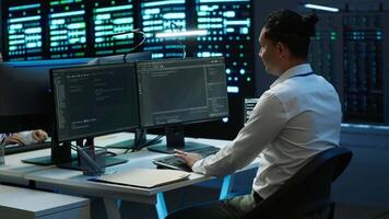 Data center system administrator responsible for installation of networking equipment solving tasks. IT employee at work doing maintenance on server room hardware, camera A video