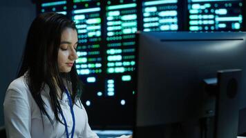 Computer scientist overseeing data center, making improvements and updates to ensure system can handle networking tasks. Close up of woman in server room tracking network traffic, camera A video
