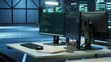 Computers in data center used for monitoring security attacks threatening supercomputers rows. PCs used by futuristic server hub workplace admins to protect equipment, handheld camera shot video