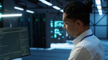 Portrait of smiling data center technician responsible for installation and repair of networking equipment solving tasks. Jolly IT expert doing maintenance on server room infrastructure, camera A video