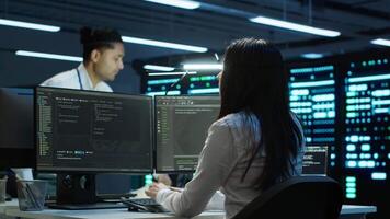 Team of researchers in data center monitoring security threats using PC, implementing cybersecurity measures. Teamworking colleagues ensuring compliance with regulations, camera A video