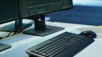 Close up of computer peripherals used by engineers coding in modern data center, monitoring security threats. PC monitors used by server room employees ensuring compliance with regulations video