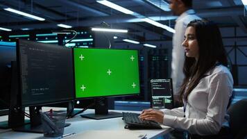 Admin in data center using mockup PC to design, implement and manage gear, ensuring optimal performance and reliability. Expert in server room coding on green screen computer, camera B video