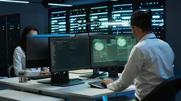 Team of programmers in server hub try to protect hardware from hacker attack stealing sensitive information. Data center cybersecurity division coworkers fight virus during security breach, camera A video