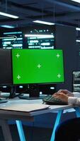 Vertical Technician using mockup computer in data center, managing servers, operating systems. Expert in server hub using green screen PC to ensure networks are secure and functioning properly, camera B video