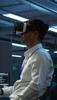 Vertical Programmer in data center managing and maintaining databases using futuristic VR headset, ensuring data integrity and security. Expert updating server room systems using virtual reality video