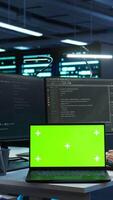 Vertical Engineer in high tech data center managing and maintaining databases using mockup devices, ensuring data integrity. Indian employees updating server room supercomputers with chroma key laptop video