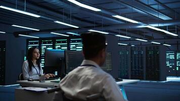 Person with disability in inclusive high tech server room facility ensuring data remains shielded from threats. Wheelchair user protecting data center hardware equipment, camera B video
