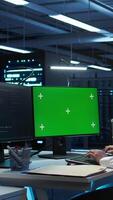 Vertical Programmer in data center managing and maintaining databases using mockup PC, ensuring data integrity and security. Expert updating server room systems using green screen computer, camera B video