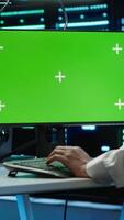 Vertical Engineer using AI tech on green screen PC to do checkup in server room. Zoom in of expert in data center using artificial intelligence on mockup computer to process datasets for training, camera A video