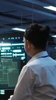 Vertical Engineer in server hub frightened by hacker passing company firewall and stealing sensitive user data. Afraid man panicks after seeing security breach notification on computer in data center, camera B video