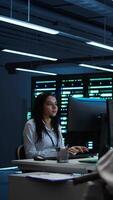 Vertical Person with disability in inclusive high tech server room facility ensuring data remains shielded from threats. Wheelchair user protecting data center hardware equipment, camera B video