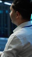 Vertical Engineer overseeing data center, making routine improvements and updates to ensure system can handle all networking tasks. Server room employee tracking network traffic and activity, camera A video