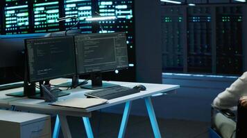 Person with disability in inclusive high tech server room facility ensuring data remains shielded from threats. Wheelchair user protecting data center hardware equipment, camera A video