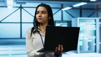 System administrator in data center monitoring security threats, implementing cybersecurity measures. Woman ensuring compliance with regulations to protect data center gear, camera A video