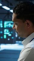 Vertical Portrait of smiling data center technician responsible for installation and repair of networking equipment solving tasks. Jolly IT expert doing maintenance on server room infrastructure, camera A video