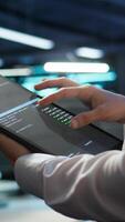 Vertical Engineer working in data center used for managing infrastructure rigs energy consumption. Employee using tablet in workplace used for automation and monitoring processes in server farm, camera B video