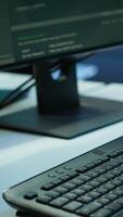 Vertical Close up of computer peripherals used by engineers coding in modern data center, monitoring security threats. PC monitors used by server room employees ensuring compliance with regulations video