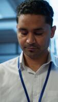 Vertical System administrator in data center managing and maintaining databases, ensuring data integrity, security and availability. IT worker updating server room supercomputers systems, camera A video