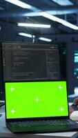 Vertical Admin in data center using isolated screen laptop to design, implement and manage gear, ensuring optimal performance and reliability. Expert in server room coding on chroma key notebook, camera B video