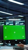 Vertical System administrator in data center installing software on green screen computer, troubleshooting issues. IT expert uses mockup PC in server hub, establishing performance benchmarks, camera B video