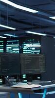 Vertical Person with paraplegia helped by coworker in data center to arrive at desk, coding on PC. Woman in wheelchair doing maintenance on server room infrastructure rackmounts, camera B video