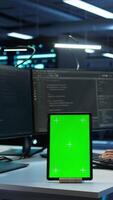 Vertical Software developer in data center monitoring security threats using mockup tablet. IT professional using green screen device, ensuring compliance with server room regulations, camera B video