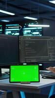Vertical Data center developer responsible for installation of networking equipment solving tasks on green screen device. Woman doing maintenance on server room infrastructure using chroma key tablet, camera B video
