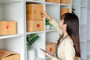 Young Woman Managing Online Orders and Inventory in a Modern Home Office Setting photo