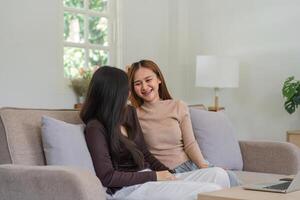 Happy Lesbian Couple Sitting Together on a Cozy Sofa at Home, Enjoying Quality Time and Smiling photo