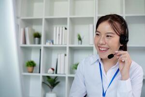 Smiling Call Center Girl Working in a Modern Office Environment with Headset and Computer photo