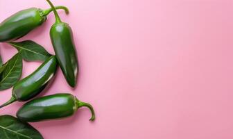Top view of a jalapeno peppers arranged on a pink background photo