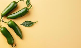 Top view of a jalapeno peppers arranged on a light yellow background photo