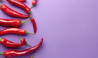 Top view of hot peppers scattered on a purple background photo