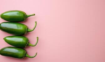 Top view of a jalapeno peppers arranged on a light pink background photo