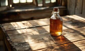 Bottle of apple syrup on a rustic wooden table photo