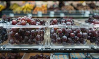 Grapes in a modern clear container on a grocery shelf photo