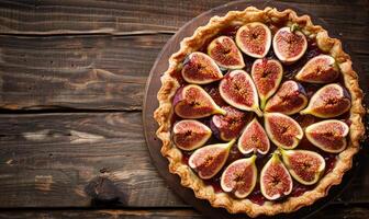 Fig tart with a golden crust topped with fresh figs, on a rustic wooden table photo