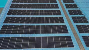 Top aerial view of solar roof system at the rooftop of factory warehouse. renewable energy of photovoltaic for reduce energy and carbon footprint. clean energy. solar panel and structure at building. video