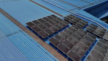 Top aerial view of solar roof system at the rooftop of factory warehouse. renewable energy of photovoltaic for reduce energy and carbon footprint. clean energy. solar panel and structure at building. video