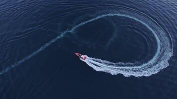 Luxury boat forms a circle of waves with its engines over the sparkling video