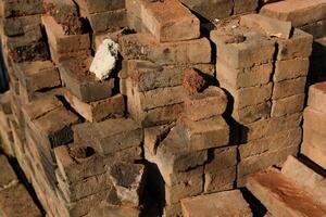 Textured Detail of mossy bricks on the side of the road. Photograph of piles of used bricks left over from house construction. Abstract Background. Construction Industry. Background Photgraphy. photo